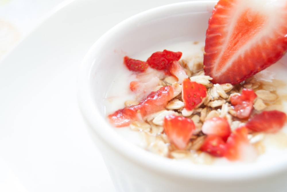 Cup of yogurt with oats and strawberry slices.