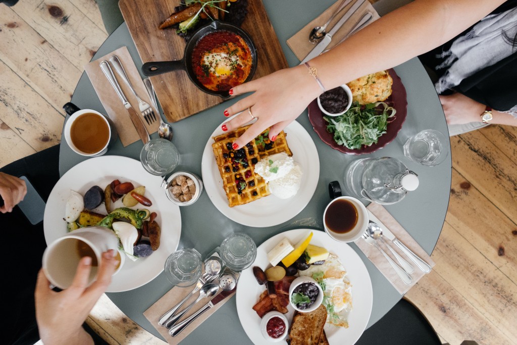 Brunch table with food, coffee and tableware.